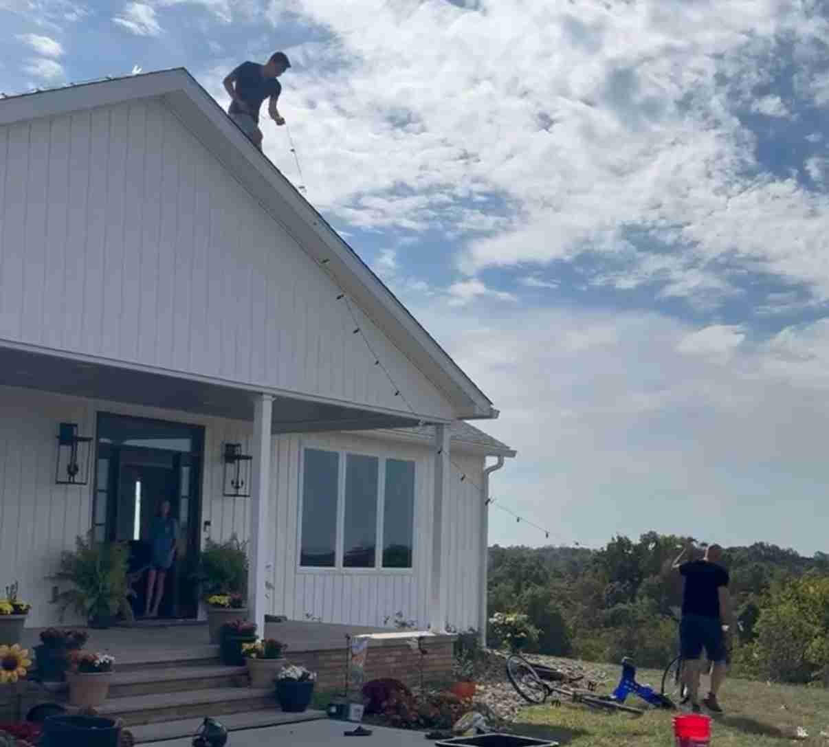Royal Lights VA team setting up Christmas lights on a house exterior