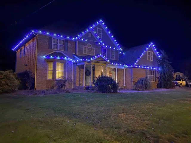 Two-story home with vibrant blue Christmas lights