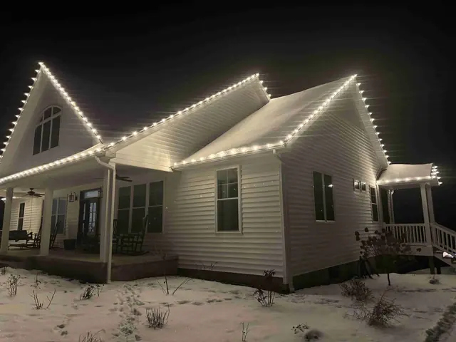 Close-up of a white house in snow with festive lights