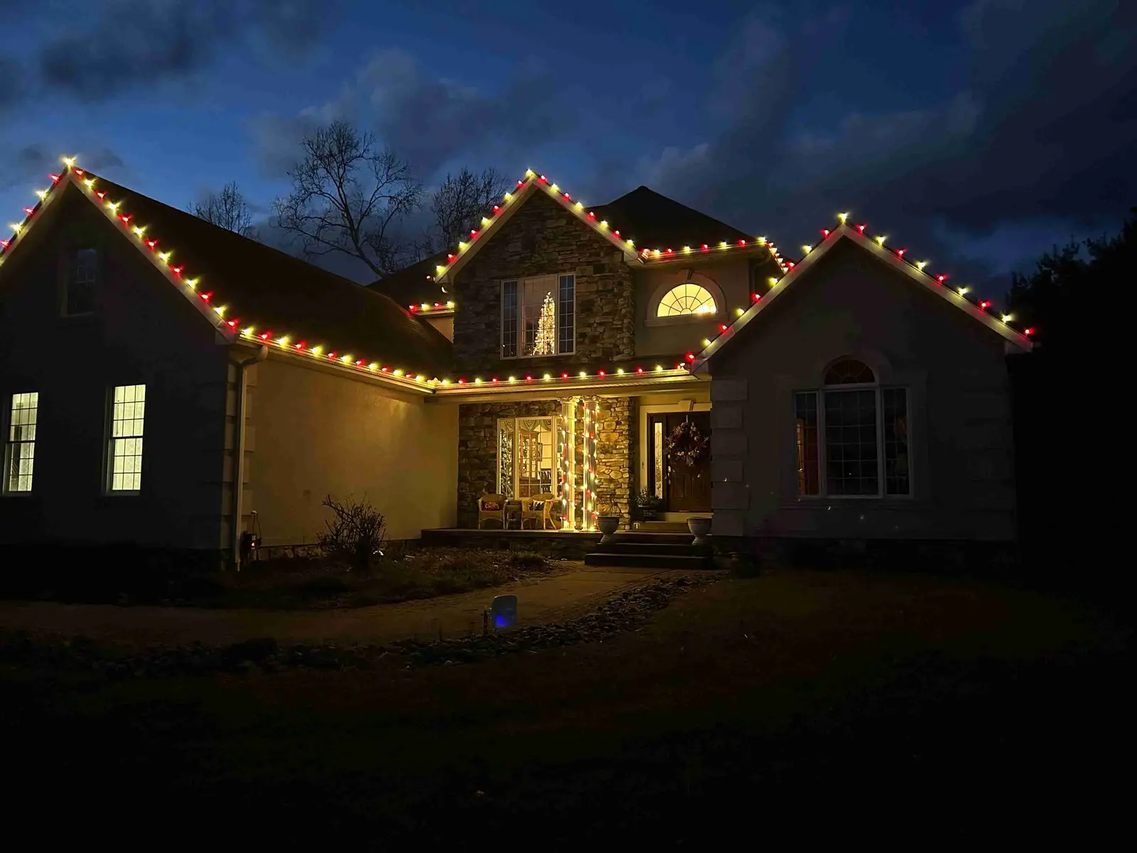 Home beautifully outlined with warm Christmas lights at dusk